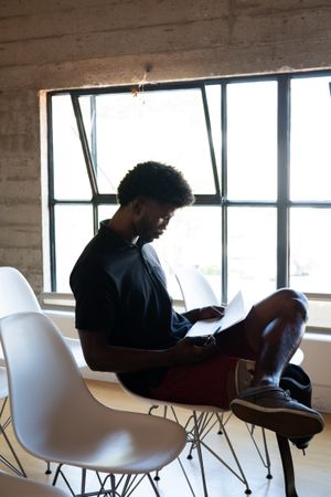 Man sitting with his notes by the window