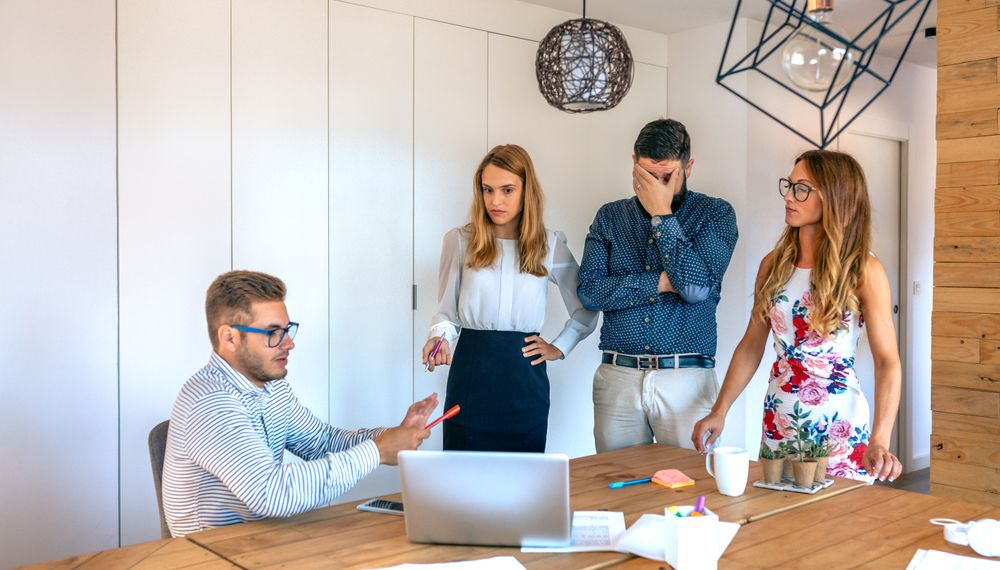 Management team scolding an incompetent worker at the office
