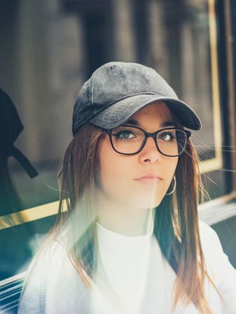 Young woman standing against glass