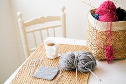 Mug of tea near knitting supplies