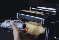 Housewife preparing homemade pasta with pasta machine