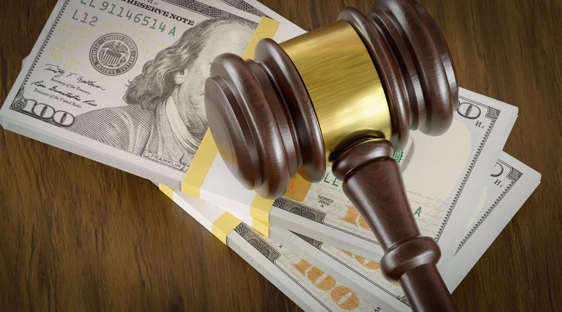 Overhead of Gavel Resting on a Table and Stack of Thousands of Dollars.