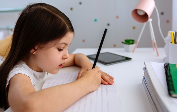 Girl doing homework in her bedroom