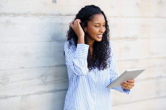 A Happy Young Woman Engaged with Her Tablet in a Stylish and Modern Indoor Setting