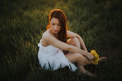 Barefoot woman with flowers in meadow