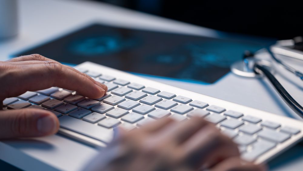 Doctor Typing on Keyboard in Office