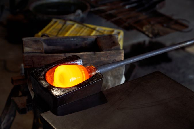 Molten glass being shaped before being blown