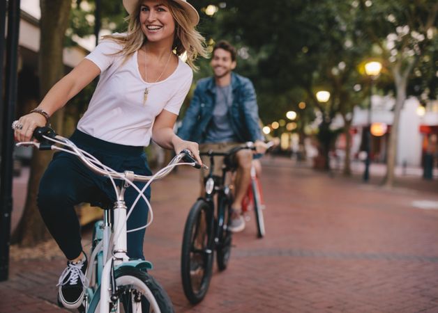 Woman cycling on city street with friends