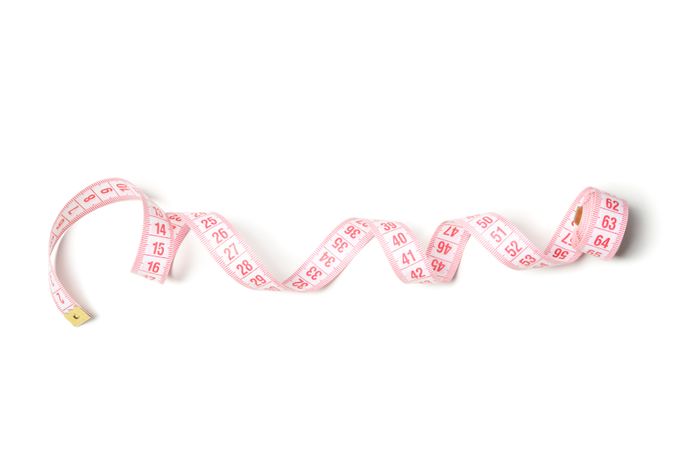Measuring tape isolated on light background. Weight loss