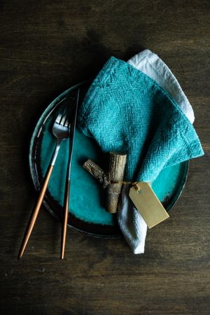 Teal plate with matching napkin and rustic wooden name card for table setting