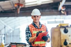 Portrait of engineer foreman in hardhat working on construction repair checklist