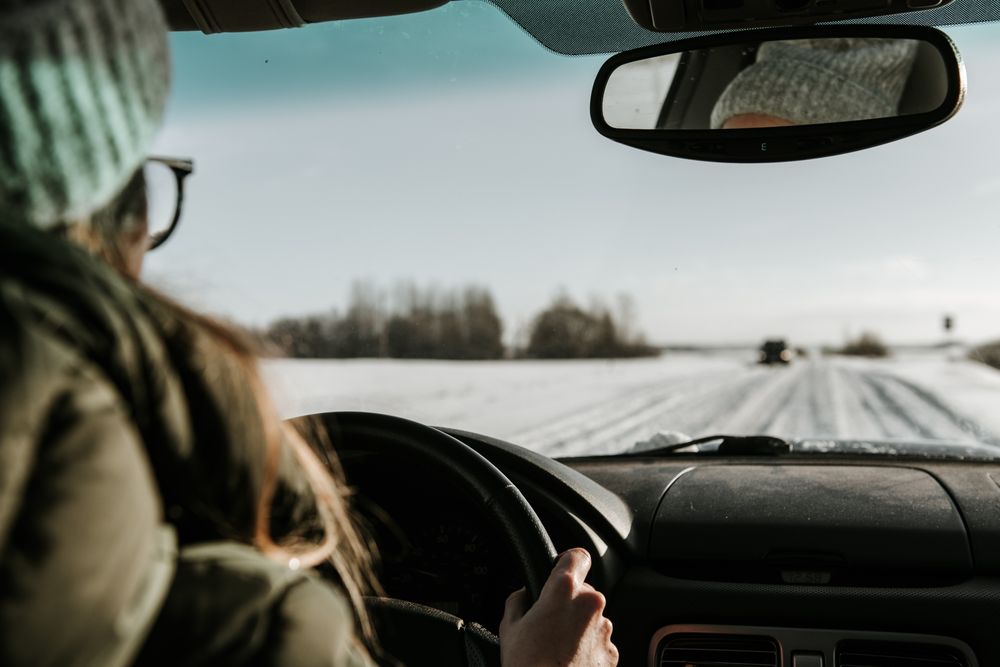 Woman driving car on snow field