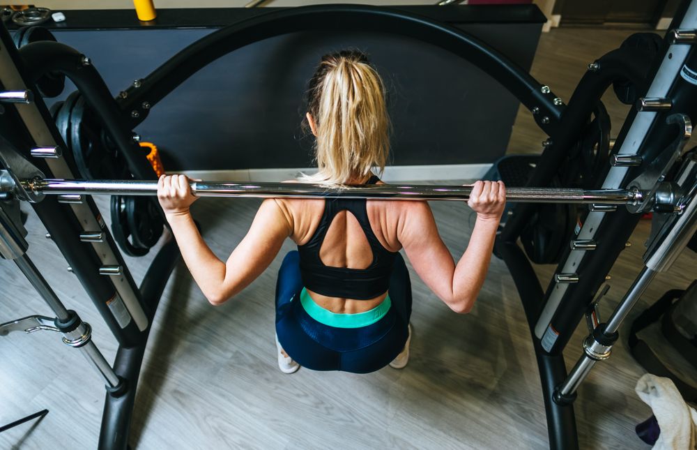 Woman lifting barbell in gym
