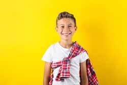 Happy boy against yellow background, space for text
