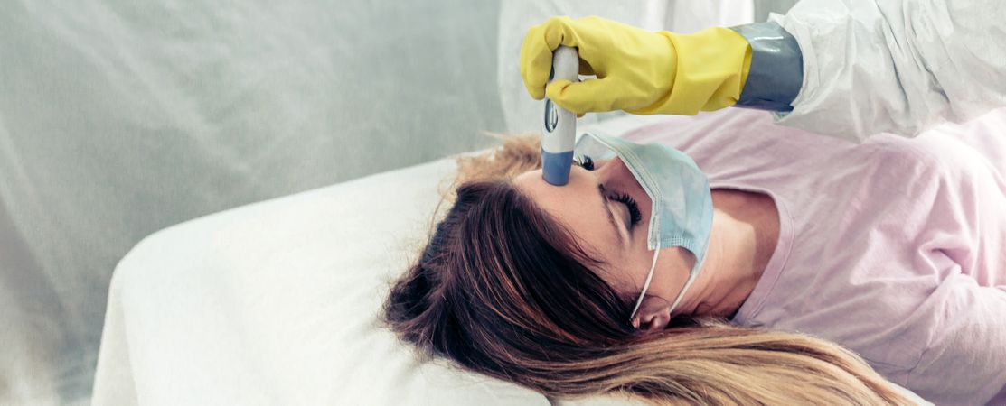 Doctors in a field hospital taking the fever a patient