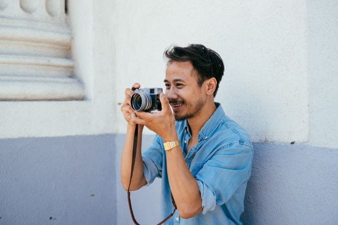 Male photographer smiling while taking a photo
