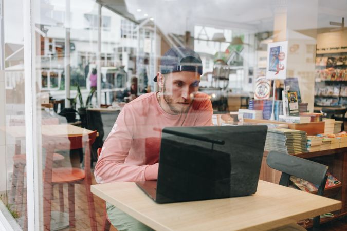 Man working in a cafe shot through glass