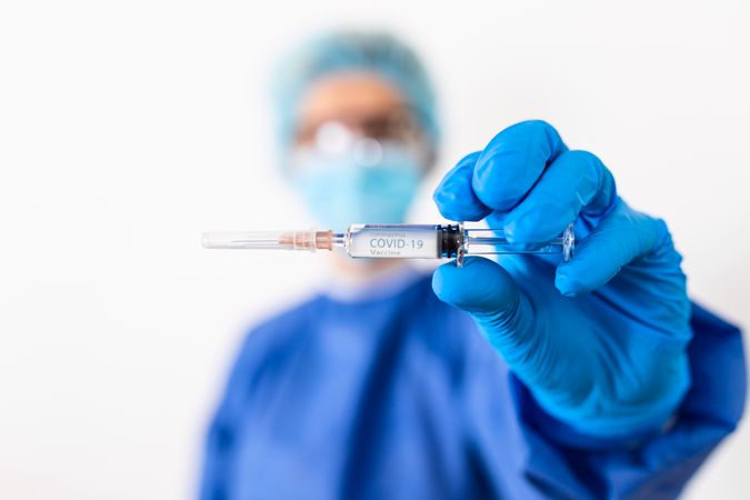 Healthcare worker holding needle in focus