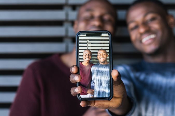 Showing photo on smartphone of Black friends