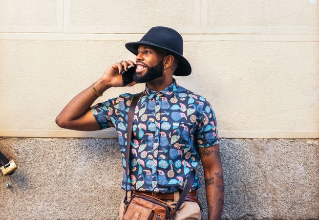 Stylish Black man talking on the phone outdoors in the city