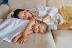 Happy mother and child sleeping on couch