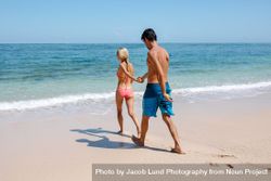 Young couple going for swim in sea 432aGx