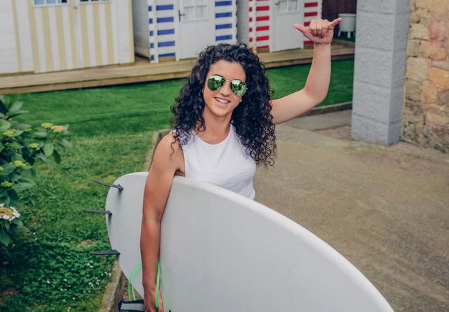 Brunette female surfer with top holding surfboard