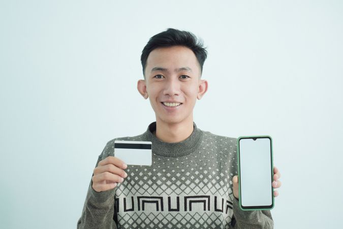 Joyful businessman wear suit with t-shirt holding blank credit card in studio shoot