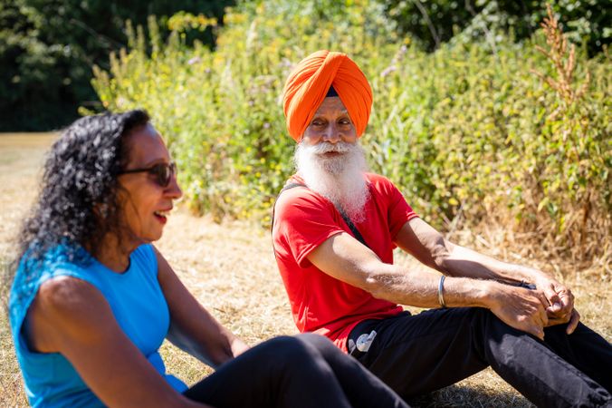 Mature Sikh couple doing sit ups together