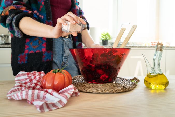 Crop woman preparing vegetable salad