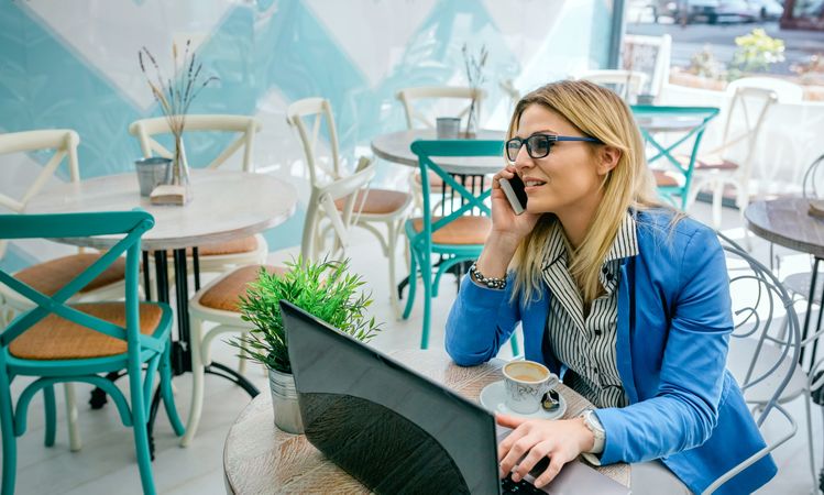 Woman talking on phone with laptop