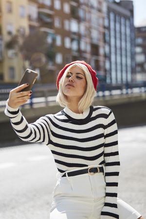 female in red beret taking selfie