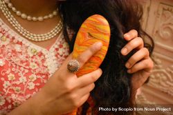 Close-up shot of woman brushing her hair 489Mvb