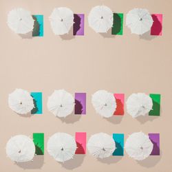 Aerial view of sun umbrellas and multicolored towels in rows on sand