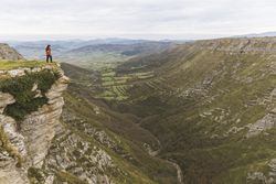 Man standing on cliff near valley