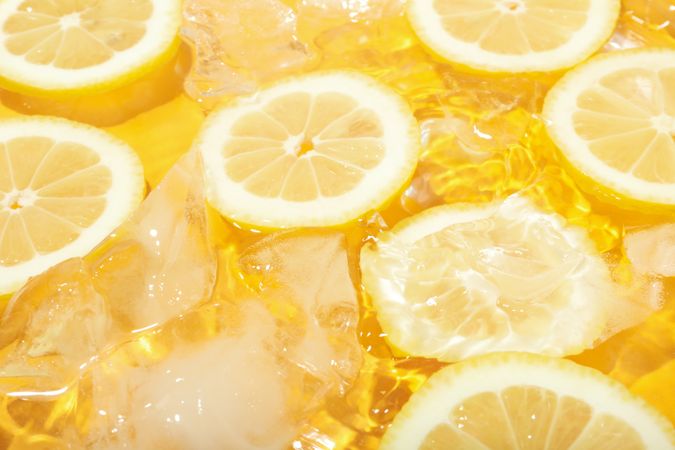 Lemon slices floating in water with ice cubes