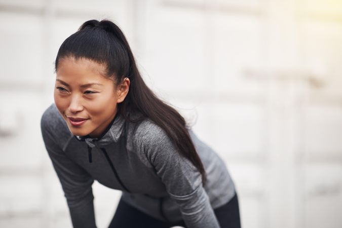 Focused woman in workout gear leaning down