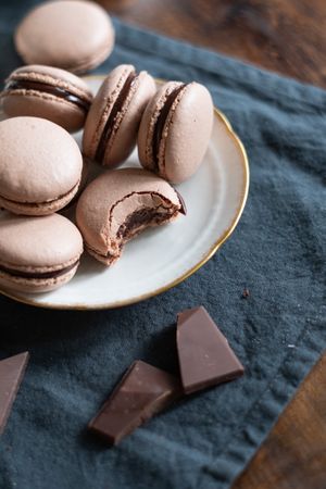 Close-up of chocolate macarons on gold rimmed plate