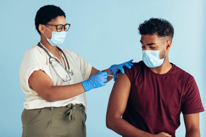 Man getting vaccinated by a female doctor