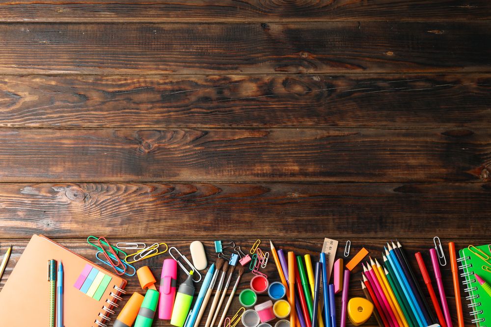 Flat lay composition with school supplies on wooden background, space for text