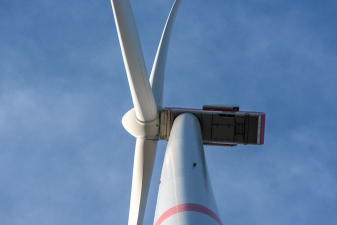 Wind turbine close-up, isolated on the blue sky, low angle view