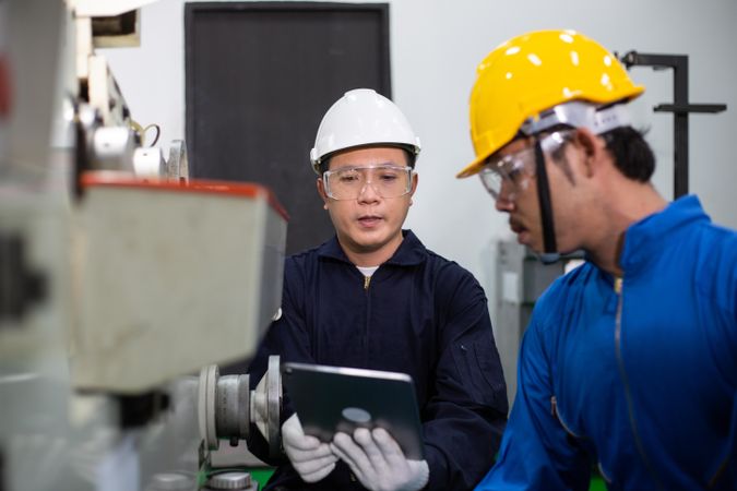 Two Asian males working together in manufacturing