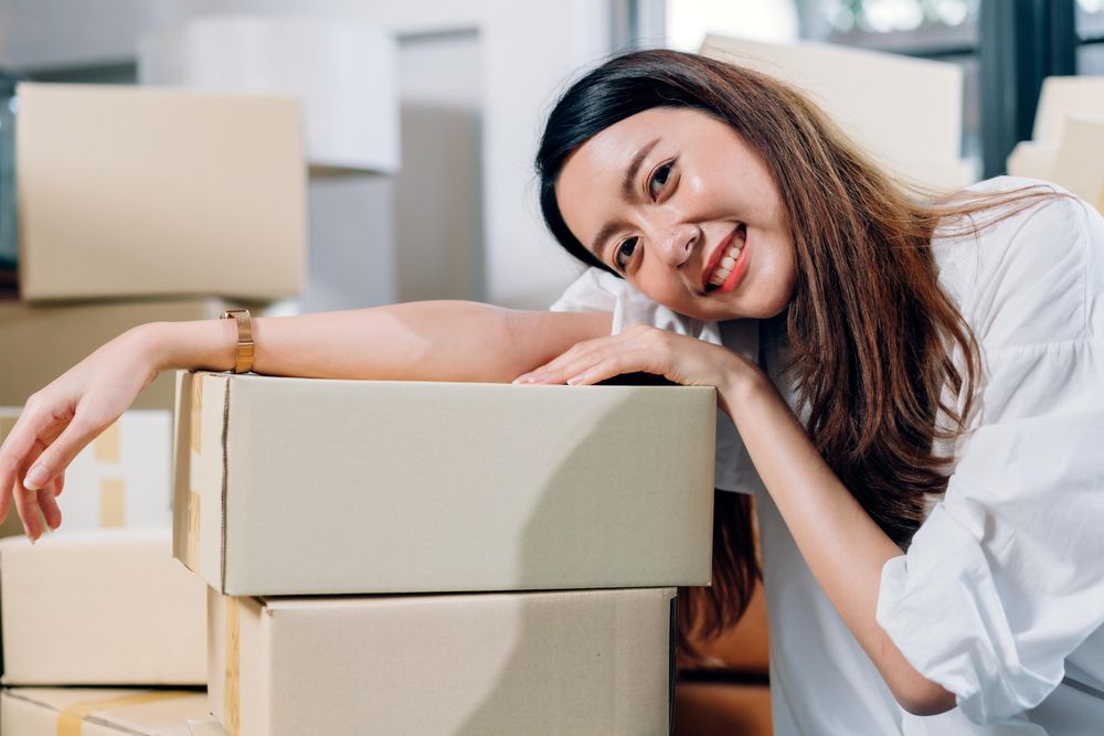 Asia young woman shop seller leaning on parcel