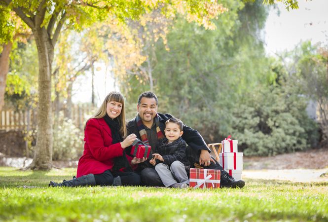 Family Enjoying Christmas Gifts in the Park Together