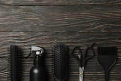 Flat lay with hairdresser accessories on wooden background, space for text