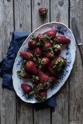 Plate with strawberries near napkin and knife