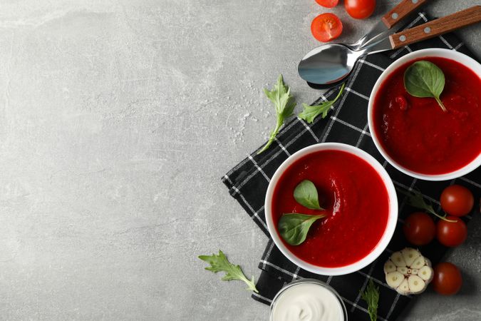 Tomato soup bowls on kitchen towel with copy space
