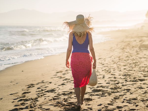 Woman holding walking along seaside