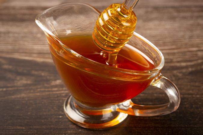 Honey in glass bowl on the table.