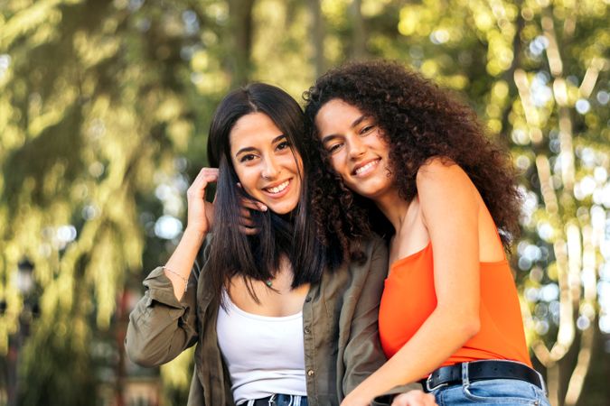 two young women sitting and hugging